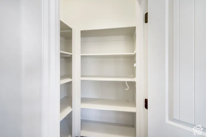 Built-in shelving with multiple levels, white finish, and a white door with vertical paneling