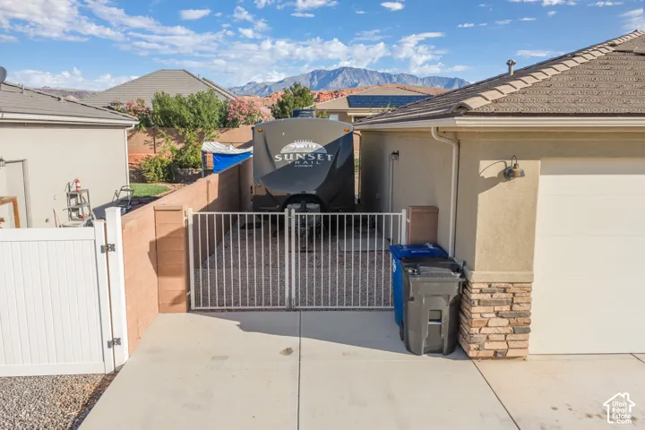 Gated gravel area with concrete block retaining walls and a concrete driveway