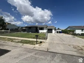 Ranch-style residence featuring a covered front porch, attached garage, and detached auxiliary structure