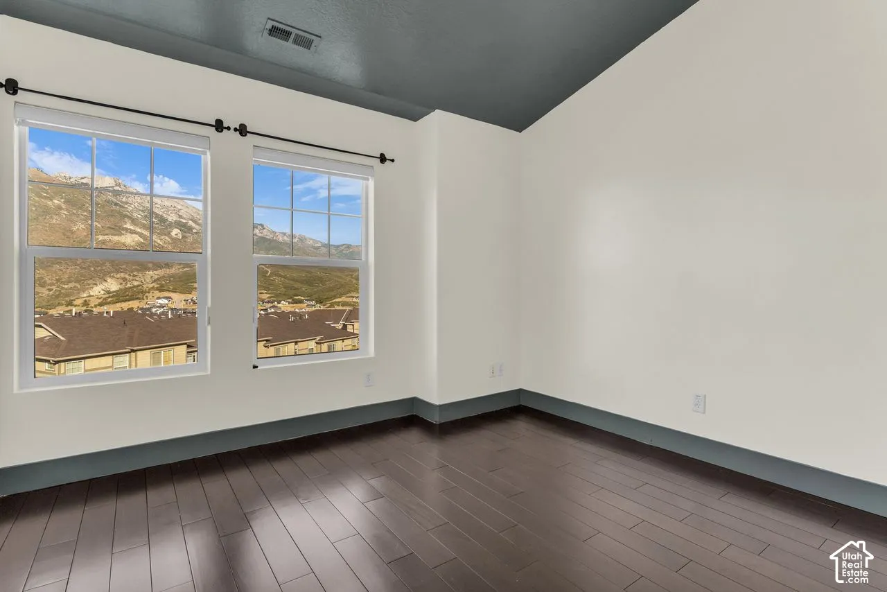 Secondary bedroom with hardwood floors, vaulted ceiling, and those mountain views!