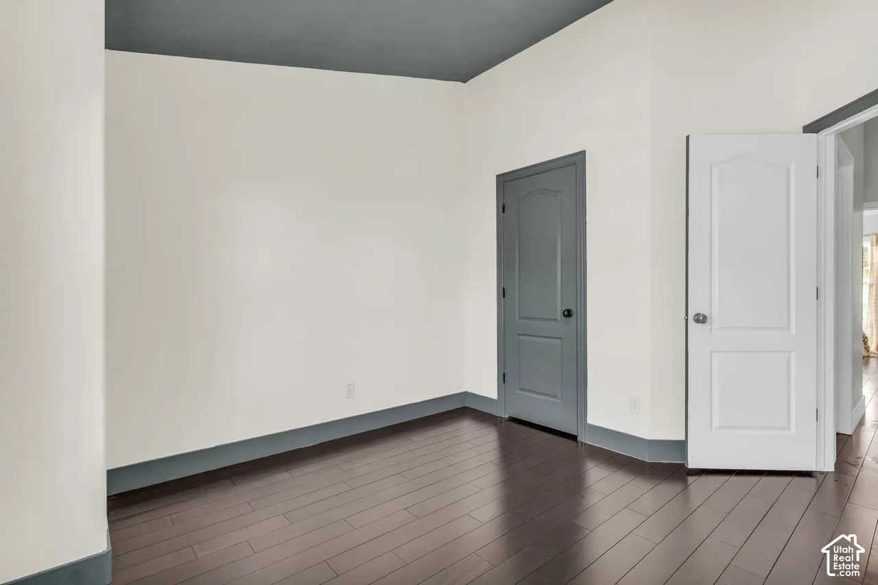 Secondary bedroom with hardwood floors and vaulted ceilings