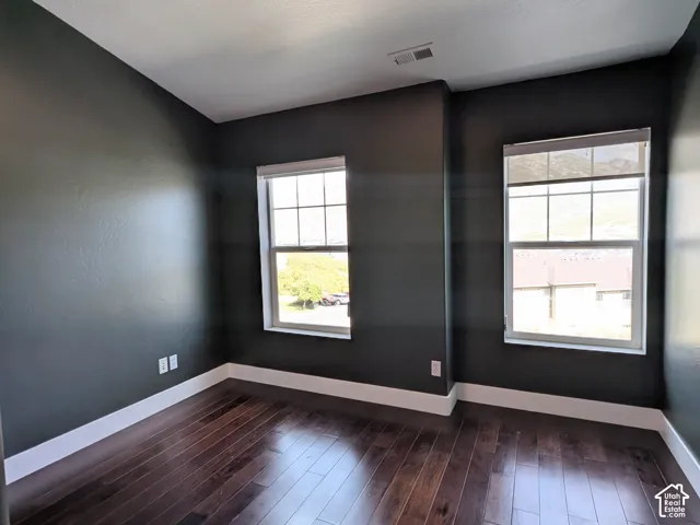 Secondary bedroom with hardwood floors, vaulted ceiling, and mountain views