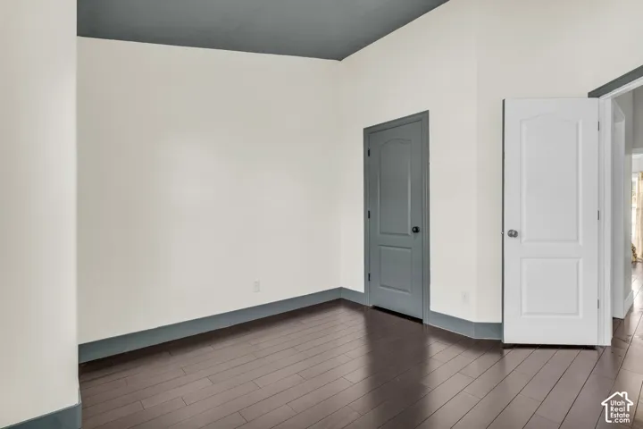 Secondary bedroom with hardwood floors and vaulted ceilings