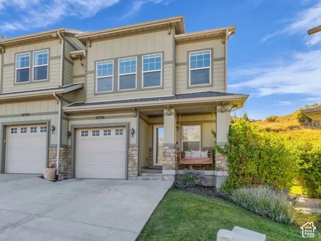 Beautiful Suncrest townhome with 1-car garage, convenient 2 -car driveway, and even a porch swing