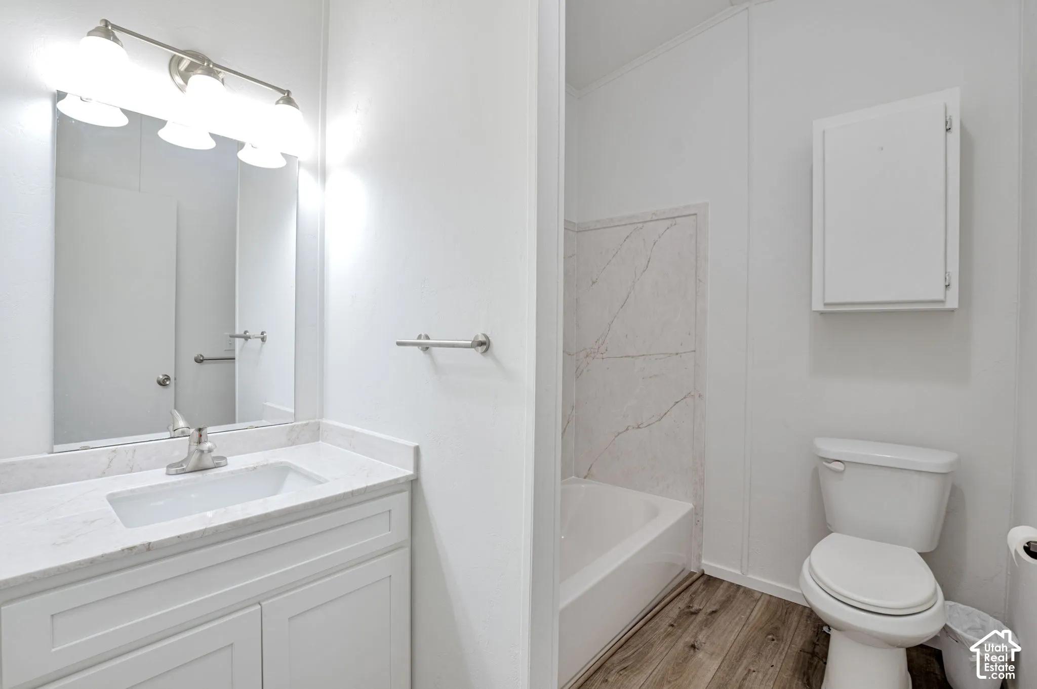 Vanity with undermount sink, countertop, framed mirror, and three-light fixture