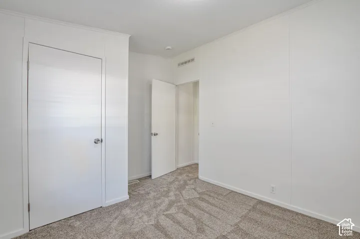 White interior walls with paneling, gray carpet flooring, white trim, and white doors