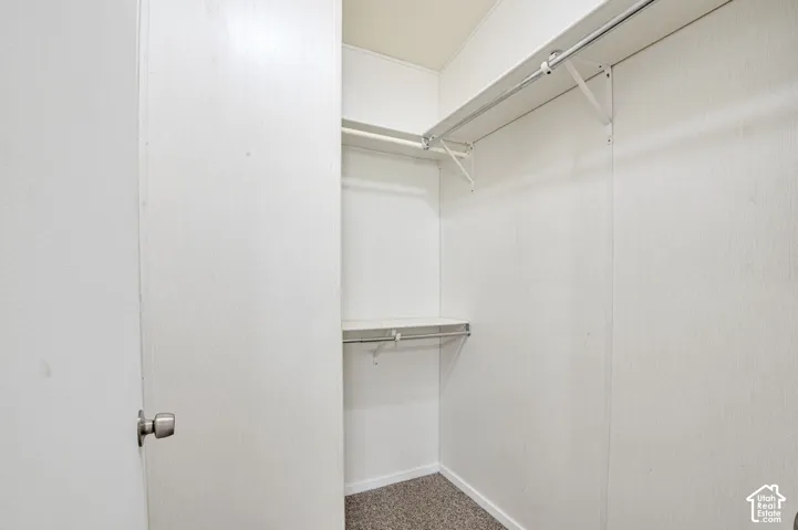 Built-in closet with two hanging rods, integrated shelving, and textured wall finish