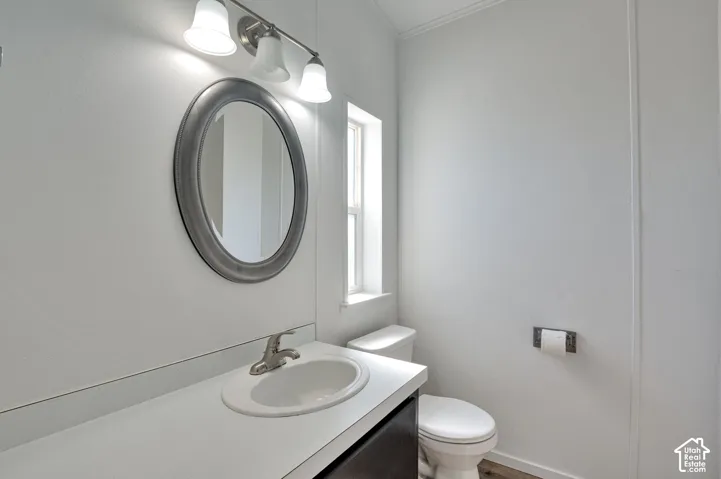 Vanity with integrated sink, brushed nickel faucet, oval mirror, and three-light fixture
