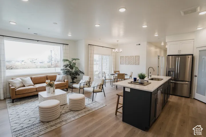 Spacious open-concept living area featuring wood-finish flooring, recessed lighting, and a large window