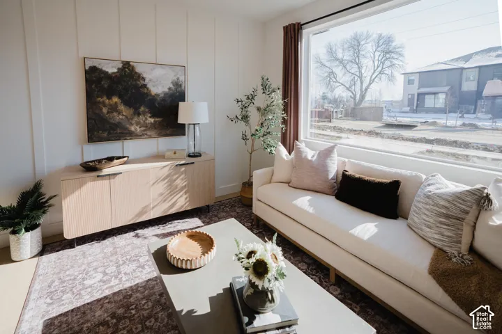 Floor-to-ceiling window, wood-finish flooring, white vertical wall paneling, built-in credenza, and neutral wall color