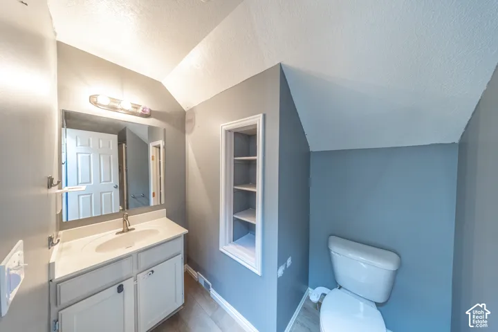 2nd floor 3/4 bath. Vanity with integrated sink, wall-mounted mirror, and built-in shelving