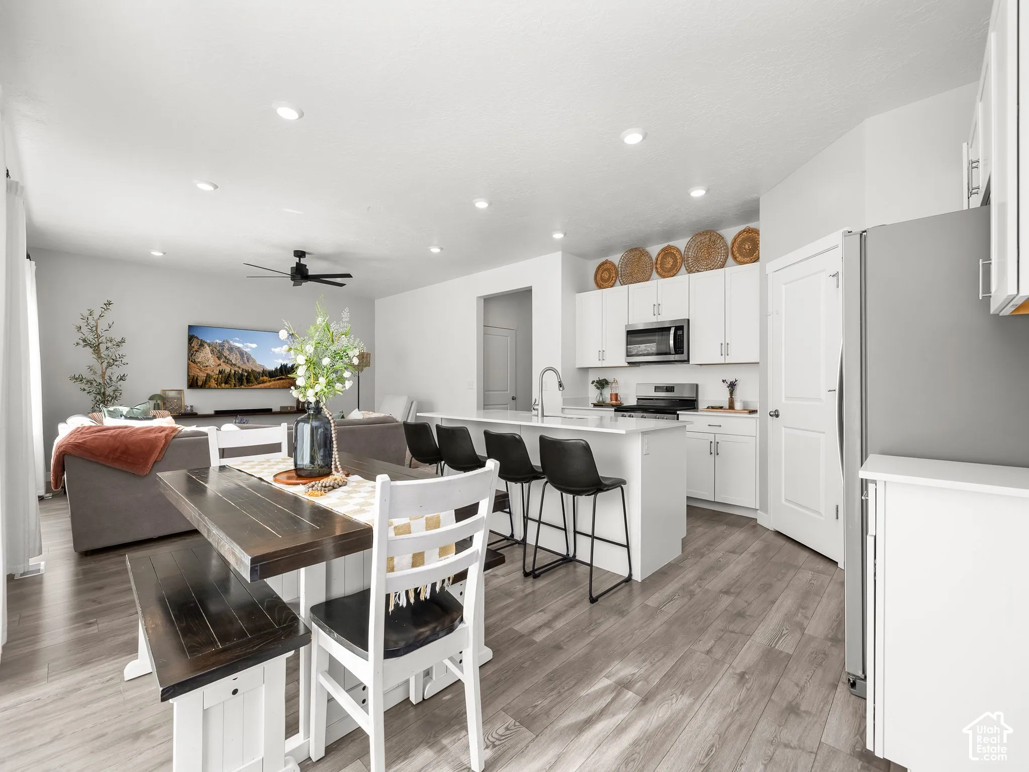 Open-concept living area with wood-finish flooring, recessed lighting, and a ceiling fan