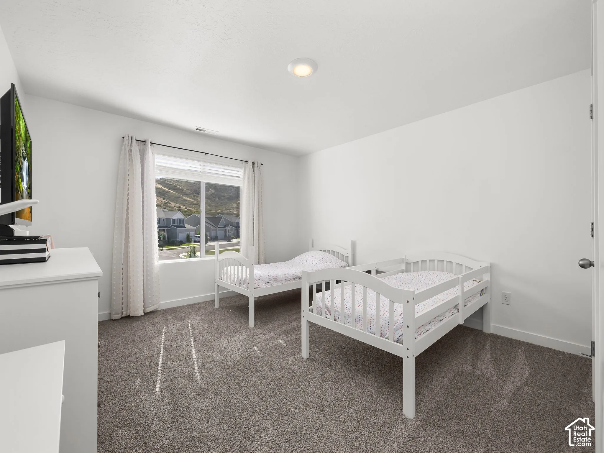 Neutral wall paint, carpet flooring, recessed ceiling light, and a window with blinds