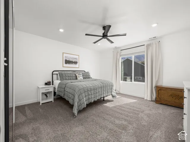 Plush carpeting, recessed ceiling lighting, a modern ceiling fan, and a large window with mountain scenery
