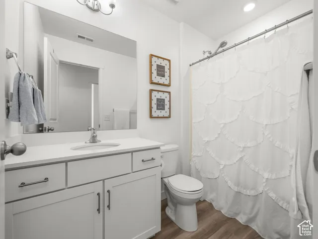 White vanity with a single basin sink and light-colored countertop