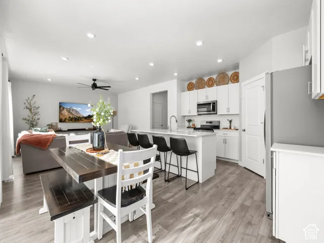 Open-concept living area with wood-finish flooring, recessed lighting, and a ceiling fan