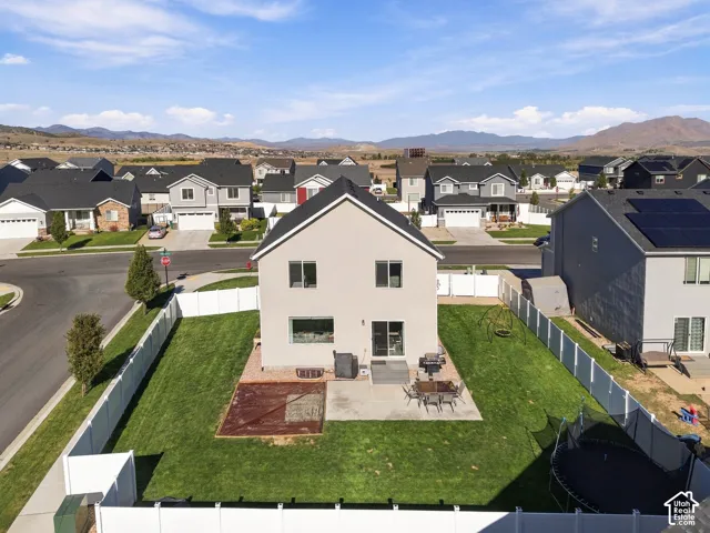 Expansive backyard featuring a patio, partial deck, and manicured lawn