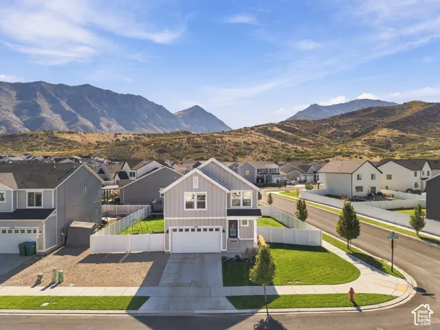 Modern two-story residence featuring a two-car garage, fenced backyard, and a manicured front lawn