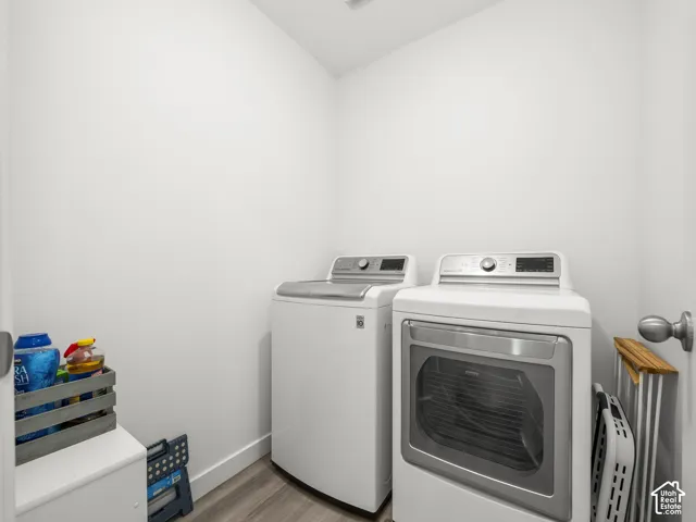Utility room with wood-finish flooring