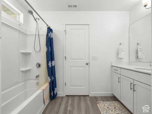 Bathroom featuring a white vanity with integrated sink, chrome faucet, and white cabinetry