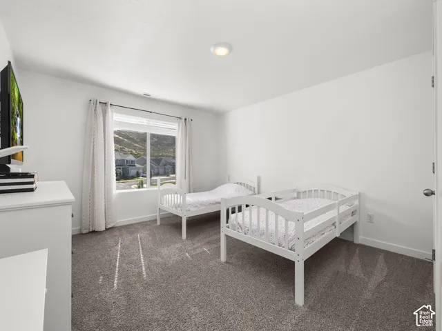 Neutral wall paint, carpet flooring, recessed ceiling light, and a window with blinds