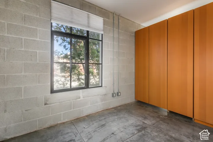 Concrete block walls with exposed conduit and sleek built-in cabinetry