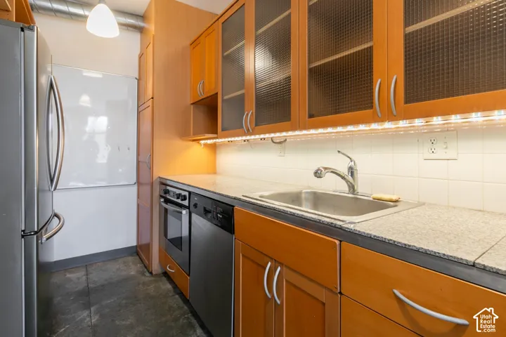Kitchen featuring wood cabinetry, stainless steel appliances, and under-cabinet lighting