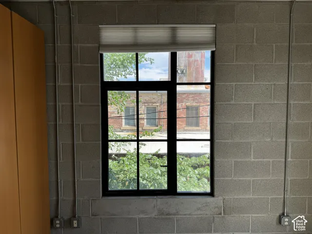 Industrial-style window with black framing and light-filtering shades