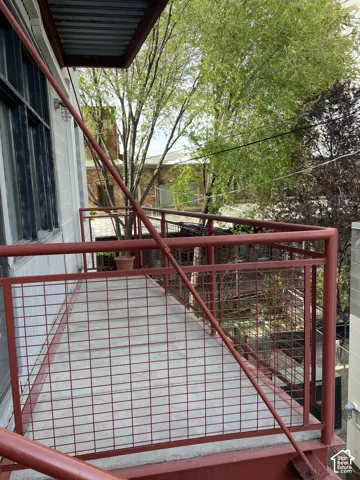 Sturdy red metal railing and gate system with welded mesh infill, offering secure outdoor access