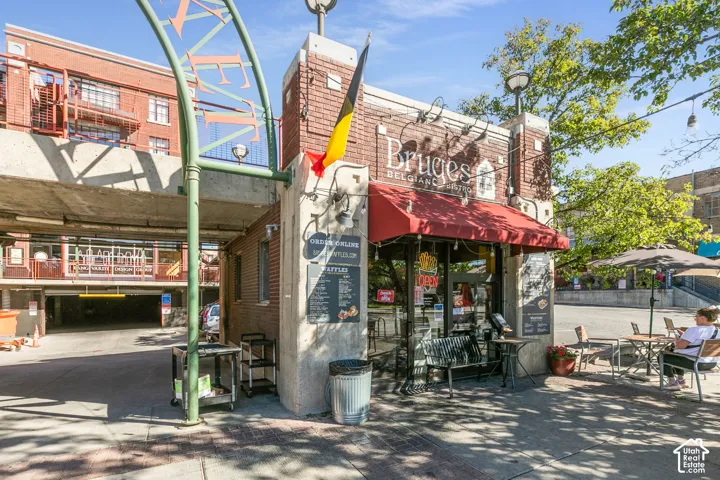Brick facade with an arched sign, red awning, and exterior lighting fixtures