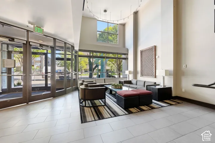 High ceilings with expansive windows, light-toned tile flooring, and integrated lighting fixtures
