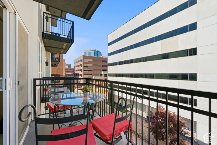 Balcony with metal railing and a glass sliding door overlooks the Dog Run below.