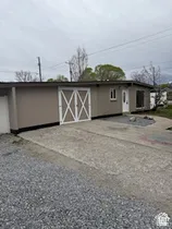 Single-story exterior with light brown siding and a contrasting dark trim