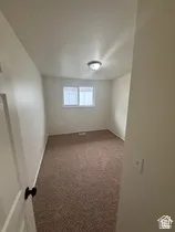Neutral wall paint, textured carpeting, and a flush-mount ceiling light fixture