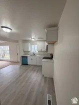 Kitchen featuring white cabinetry, light countertops, and wood-finish flooring