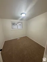 Neutral wall color, carpeted flooring, window, and flush mount ceiling light