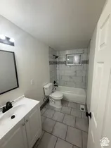 White vanity with a single basin sink and matte black faucet