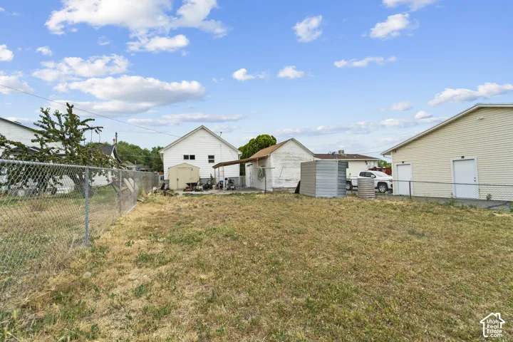 Spacious backyard with mature landscaping, detached garage, and multiple outbuildings