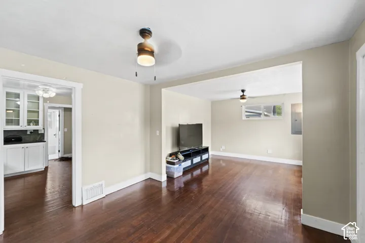 Wood-finish flooring throughout, framed openings, ceiling fans, and built-in cabinetry with glass-front uppers
