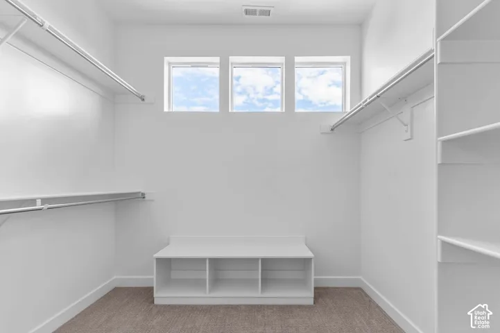 Integrated shelving system, multiple hanging rods, built-in storage bench, and three transom windows