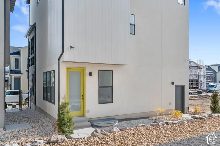 Contemporary exterior with light-toned stucco and vertical siding accents