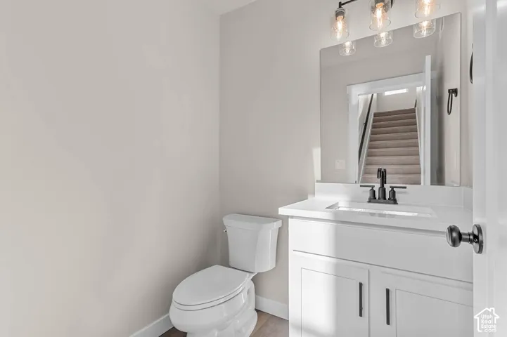 White vanity with shaker-style cabinetry, a white countertop, and a rectangular undermount sink