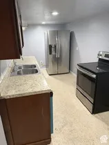 Stainless steel appliances, double basin sink, granite-finish countertop, dark wood-finish cabinetry, and recessed lighting