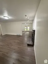 Spacious interior featuring wood-finish flooring, a decorative fireplace, and white walls