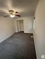 Recessed closet with a clothing rod, ceiling fan with light fixture, window with trim, and neutral-toned wall paint