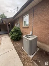 Brick exterior, concrete pathway, established shrubbery, window with light-colored trim, Lennox air conditioning unit