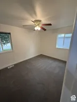 Wall-to-wall carpeting with a ceiling fan light fixture