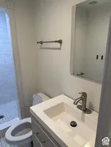 White vanity with an integrated rectangular sink, brushed nickel faucet, and coordinating mirror