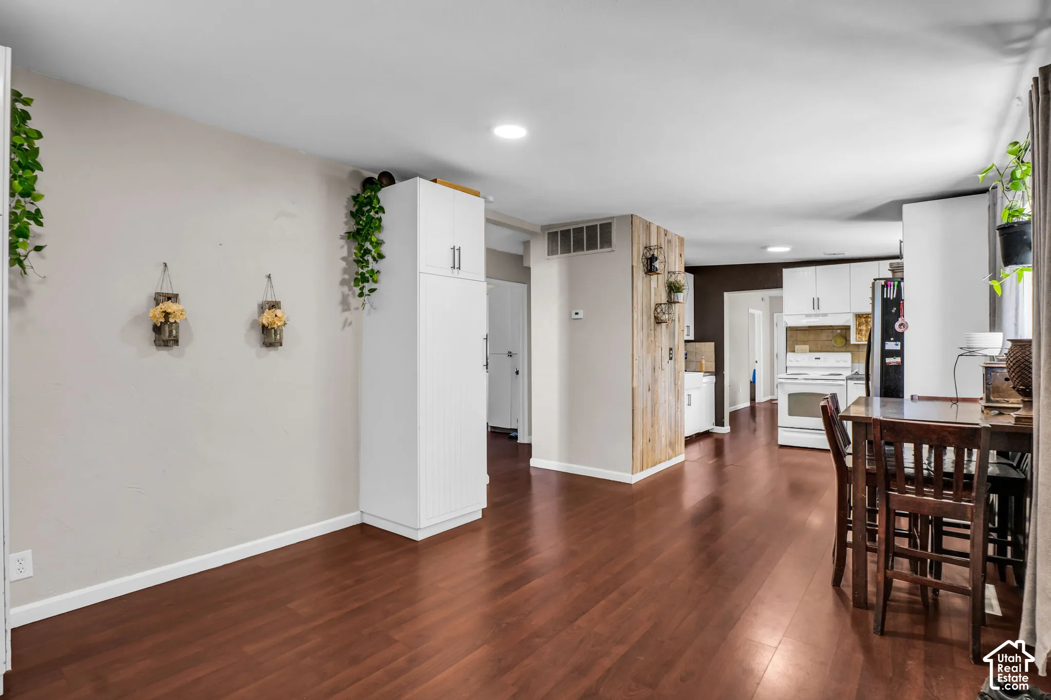 Wood-finish flooring throughout, recessed lighting, and a kitchen with white cabinetry