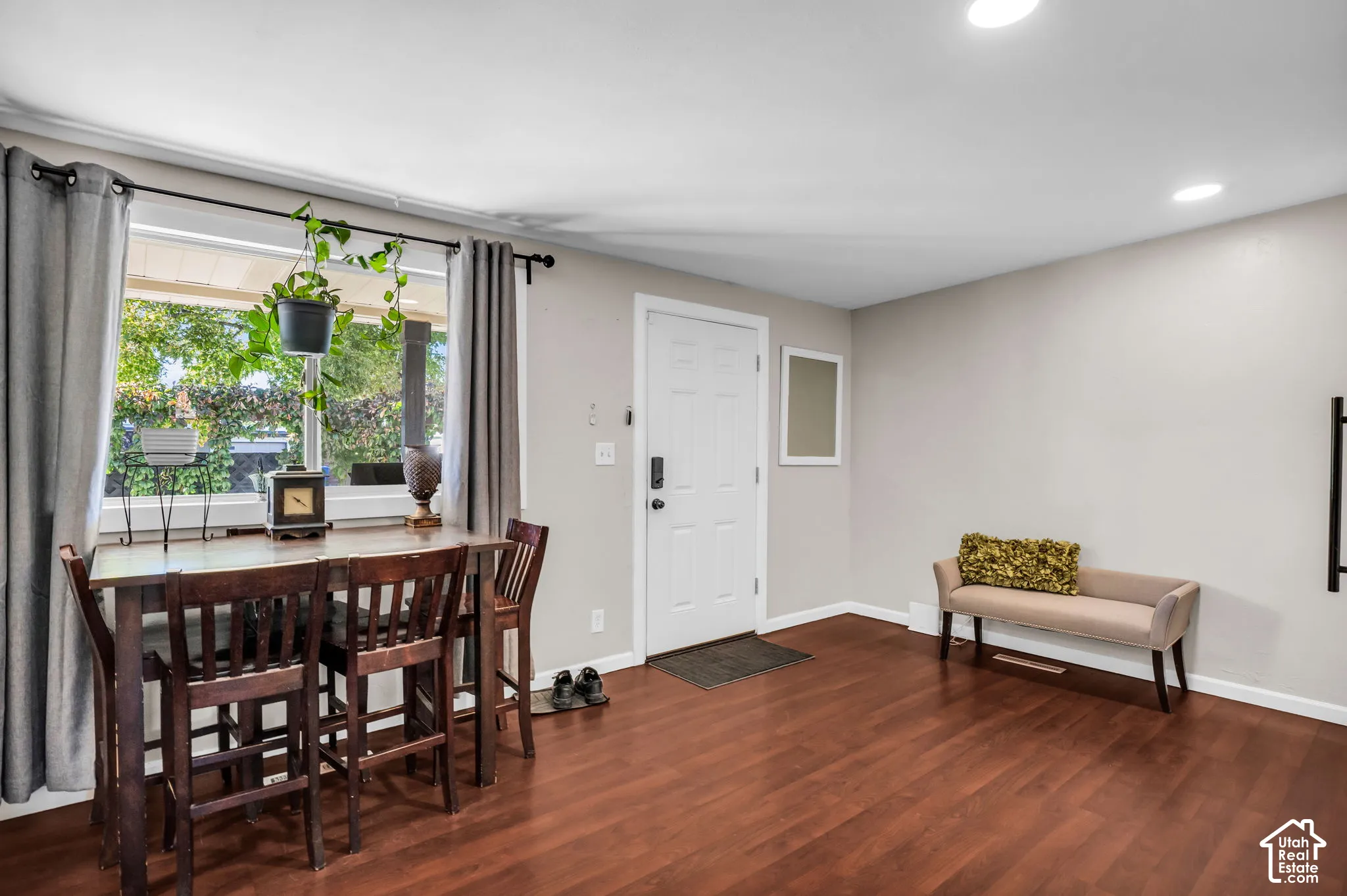Wood-finish flooring, recessed lighting, and a white entry door